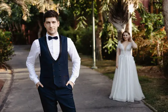 Stylowy portret pana młodego z panną młodą w tle w ogrodach Abama Resort sesja ślubna