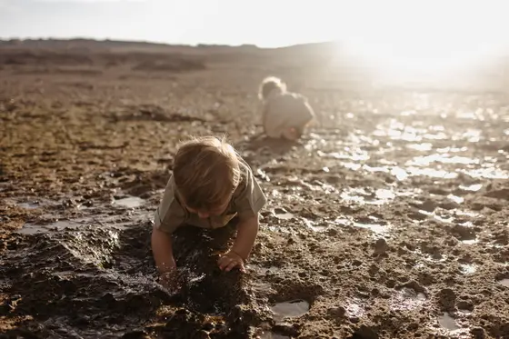 Dzieci bawiące się na wulkanicznej plaży podczas sesji rodzinnej Teneryfa wakacje radosne wspomnienia