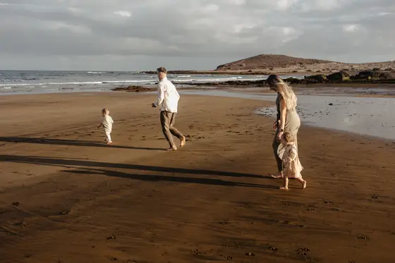 Rodzina biegająca po plaży Teneryfa sesja rodzinna wakacje aktywny wypoczynek góry w tle